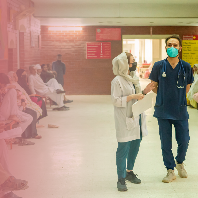 Female and male hospital staff conferring in a hallway in Pakistan