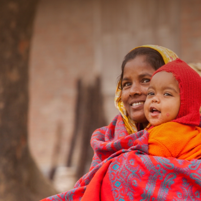 Mom and baby in red hat in South Asia
