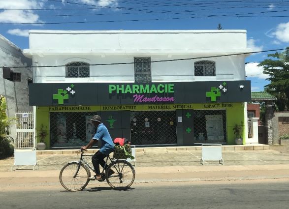 A man biking in front of a pharmacy in Madagascar 